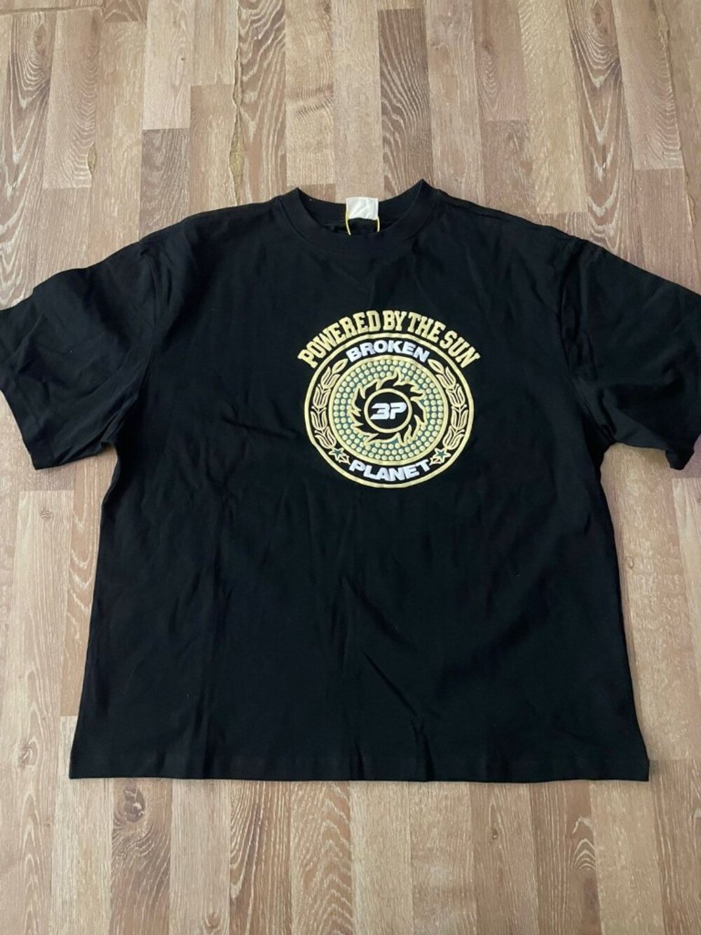 Broken Planet Market Powered By The Sun T-Shirt Black Gold Oversized Graphic Tee